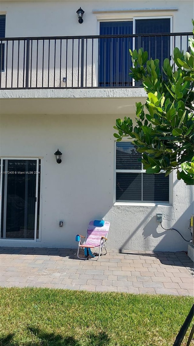 rear view of house featuring a patio and a balcony