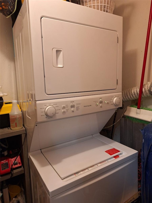 washroom with stacked washing maching and dryer