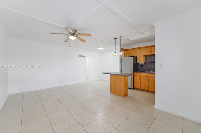 kitchen featuring ceiling fan, coffered ceiling, backsplash, hanging light fixtures, and stainless steel fridge