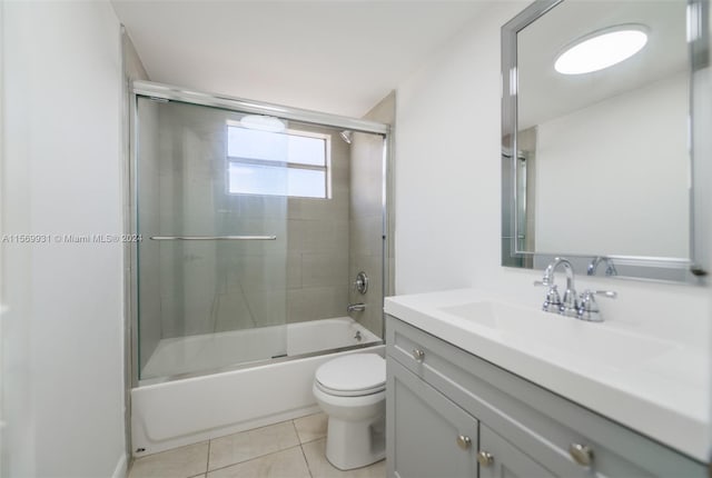 full bathroom featuring vanity, tile floors, toilet, and combined bath / shower with glass door