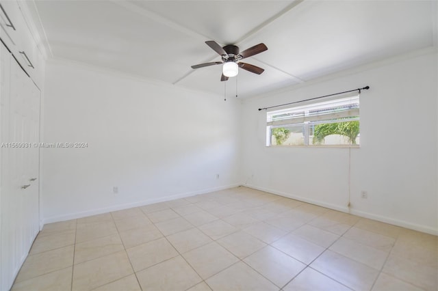 spare room with ceiling fan and light tile floors