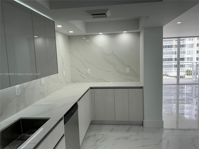 kitchen featuring light tile flooring, floor to ceiling windows, stainless steel dishwasher, and light stone countertops