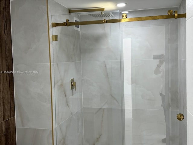 bathroom featuring a shower with door