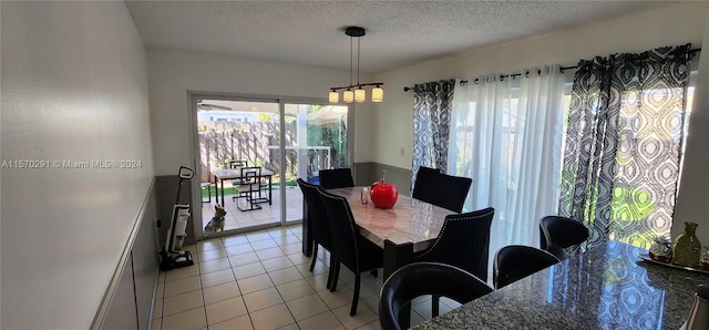 dining space featuring a textured ceiling and light tile floors