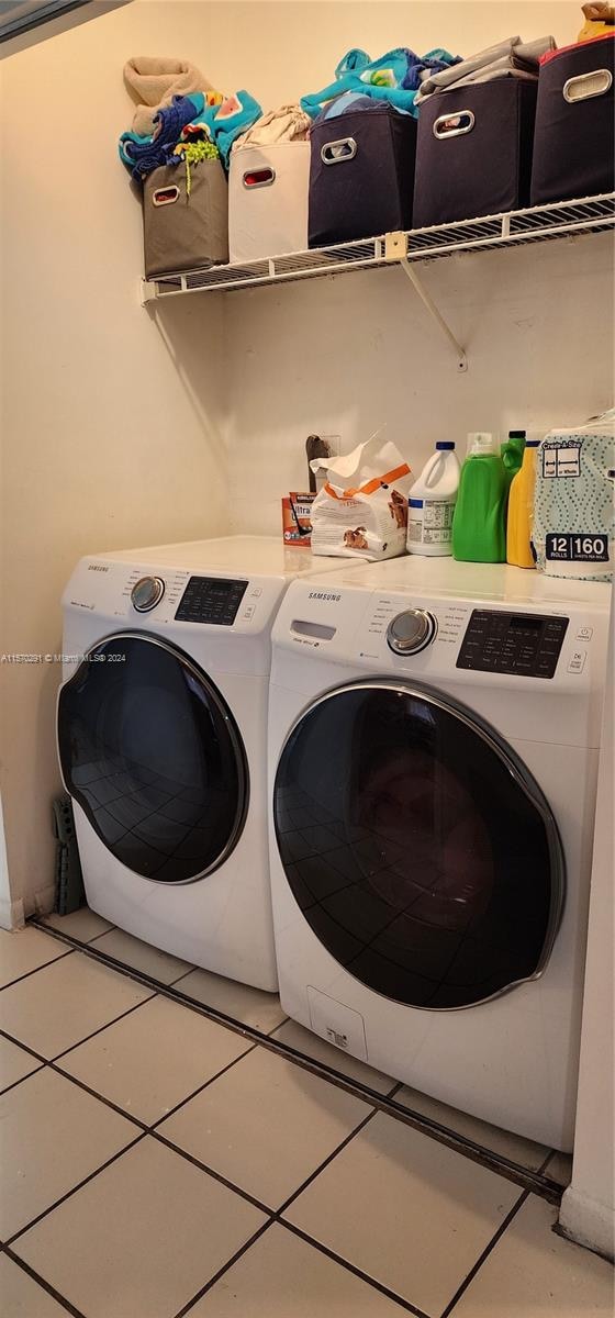 clothes washing area featuring tile flooring and separate washer and dryer