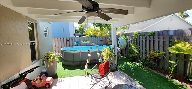 view of patio with ceiling fan and a fenced in pool