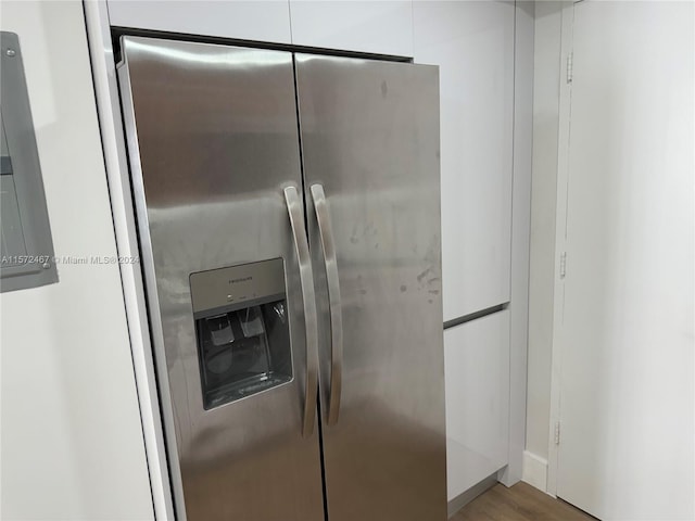 kitchen featuring hardwood / wood-style floors, white cabinets, and stainless steel refrigerator with ice dispenser