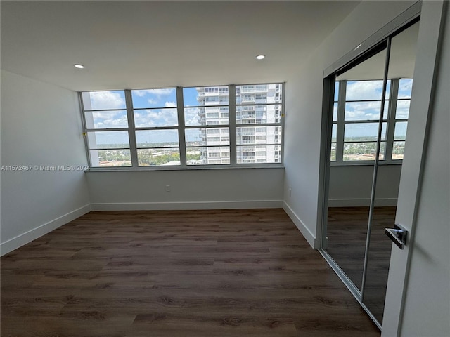 empty room with plenty of natural light and dark wood-type flooring