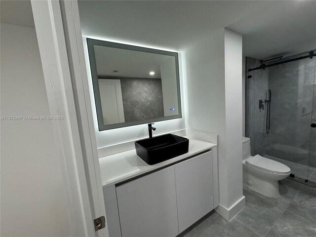 bathroom featuring tile floors, vanity, an enclosed shower, and toilet