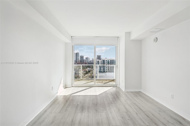 empty room with expansive windows and light wood-type flooring