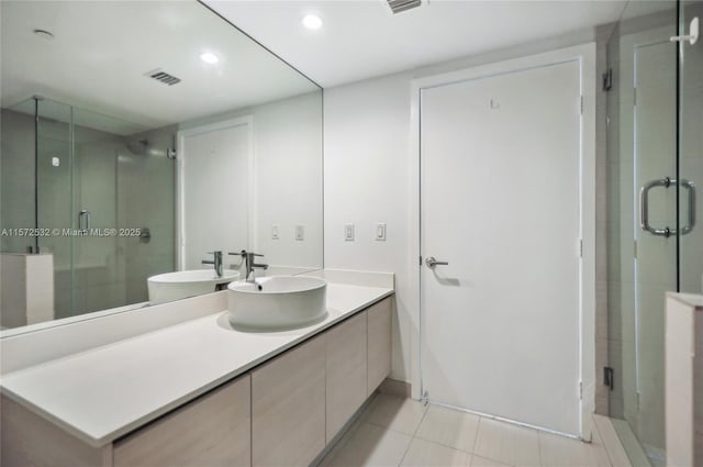 bathroom with tile patterned flooring, vanity, and walk in shower