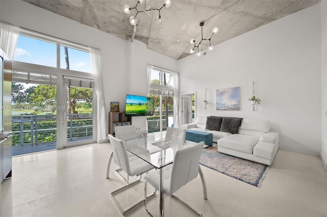 living room with a notable chandelier and a towering ceiling