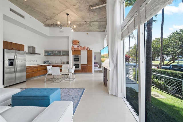 living room with sink, a towering ceiling, and a chandelier