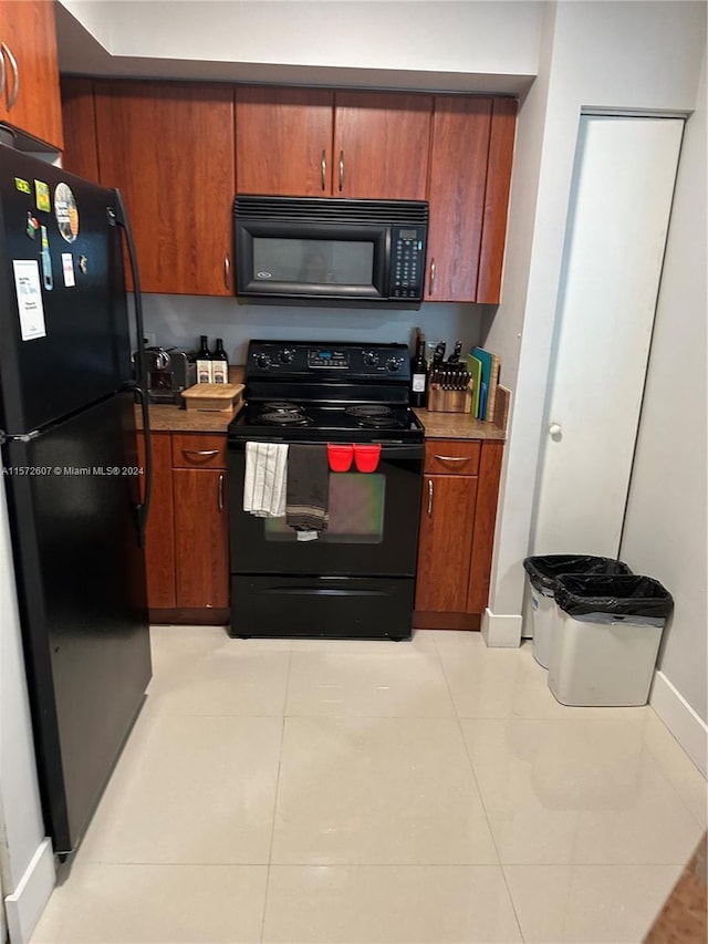 kitchen with light tile floors and black appliances