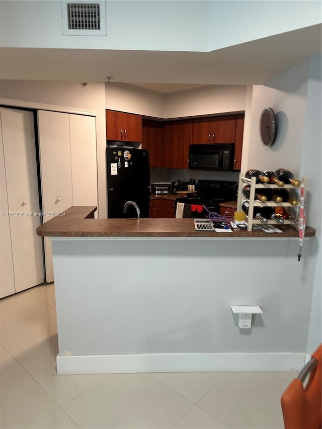 kitchen featuring sink, kitchen peninsula, light tile floors, and black appliances