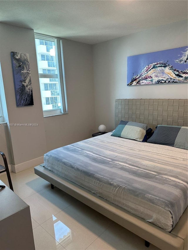 tiled bedroom featuring a textured ceiling