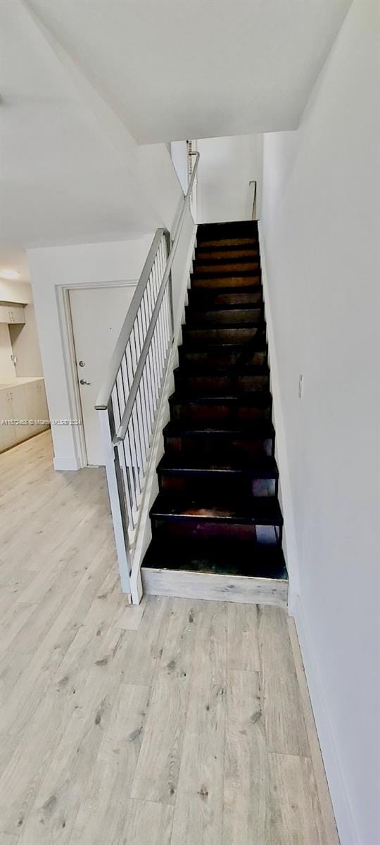 stairway featuring wood-type flooring