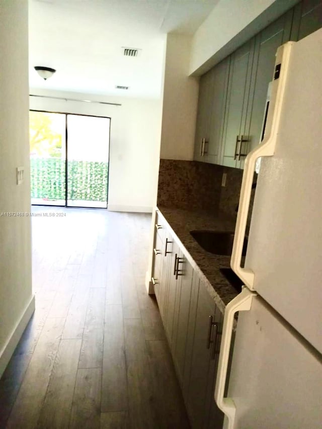 kitchen featuring white fridge, wood-type flooring, and sink