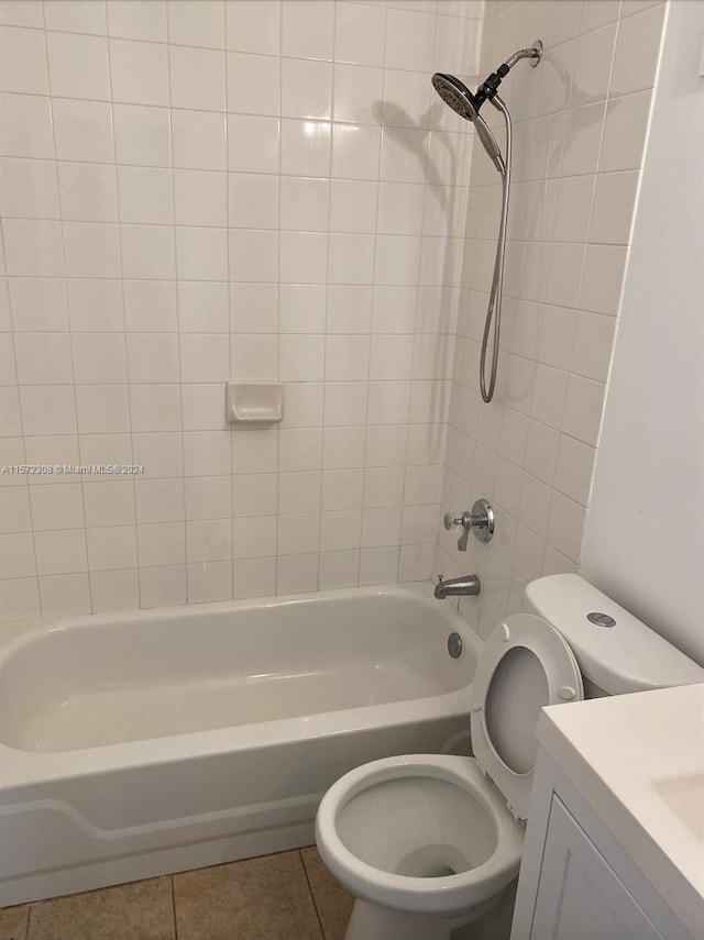 full bathroom featuring tile patterned flooring, vanity, tiled shower / bath combo, and toilet