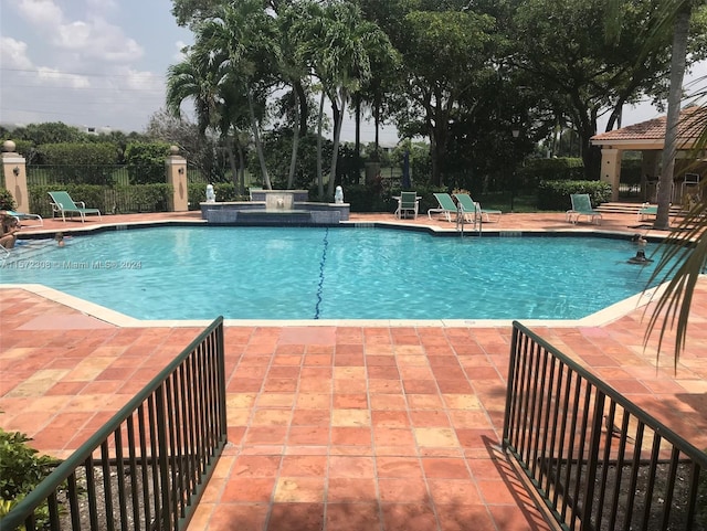 view of pool with a jacuzzi and a patio