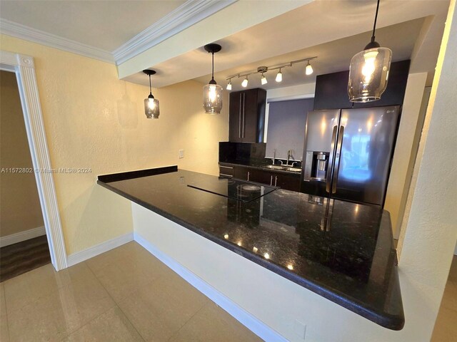 kitchen featuring pendant lighting, sink, ornamental molding, kitchen peninsula, and stainless steel refrigerator with ice dispenser