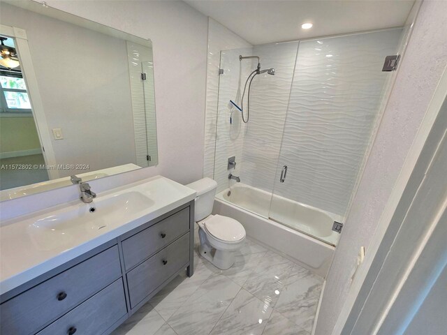 full bathroom with vanity, shower / bath combination with glass door, and toilet