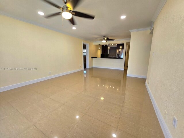 spare room featuring crown molding, tile patterned floors, and ceiling fan