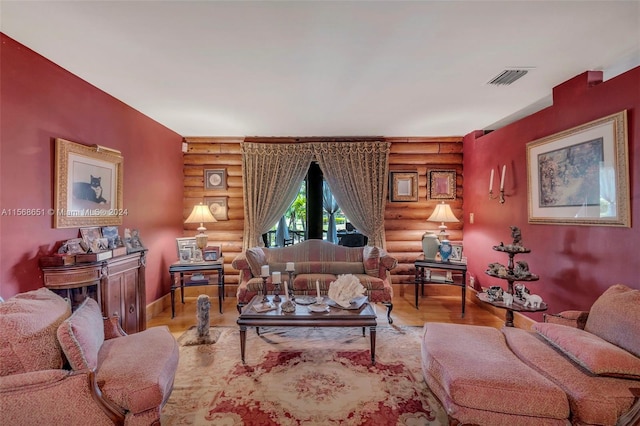 living room featuring light hardwood / wood-style floors and log walls