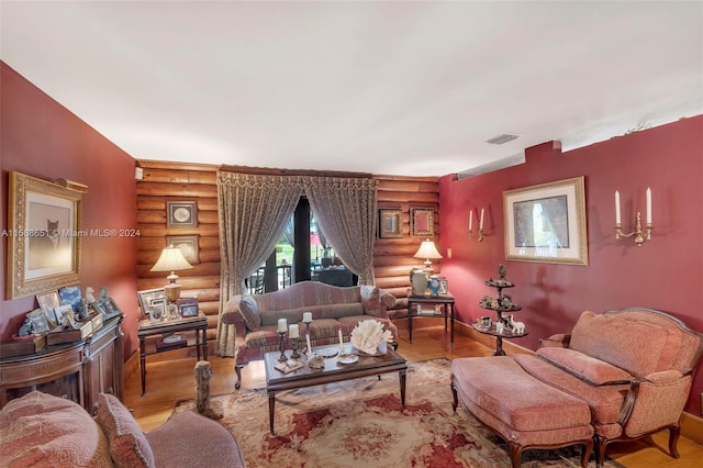 living room with light hardwood / wood-style flooring, log walls, and french doors