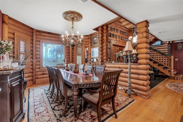 dining room with log walls, light hardwood / wood-style flooring, and a chandelier