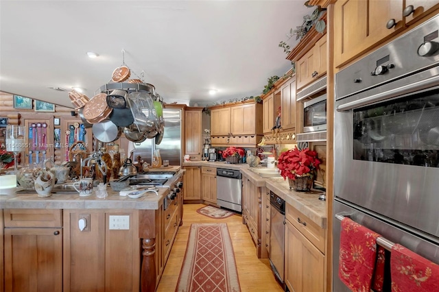 kitchen featuring light brown cabinets, stainless steel appliances, lofted ceiling, and light hardwood / wood-style flooring