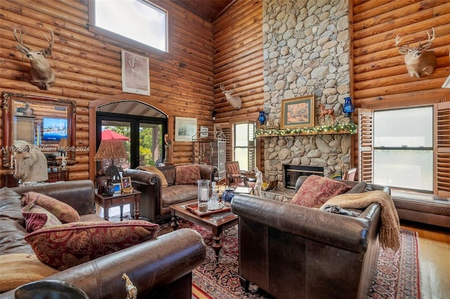 living room featuring a towering ceiling, hardwood / wood-style floors, log walls, and a fireplace