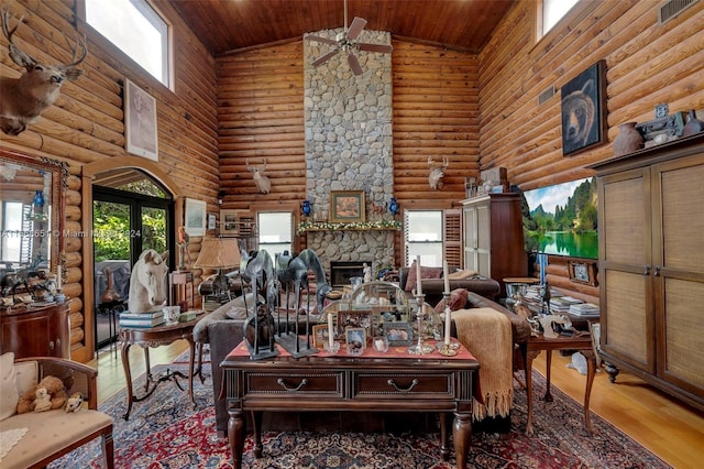 living room with a healthy amount of sunlight, a fireplace, and high vaulted ceiling