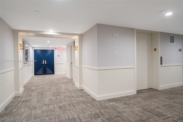 corridor with light colored carpet and elevator