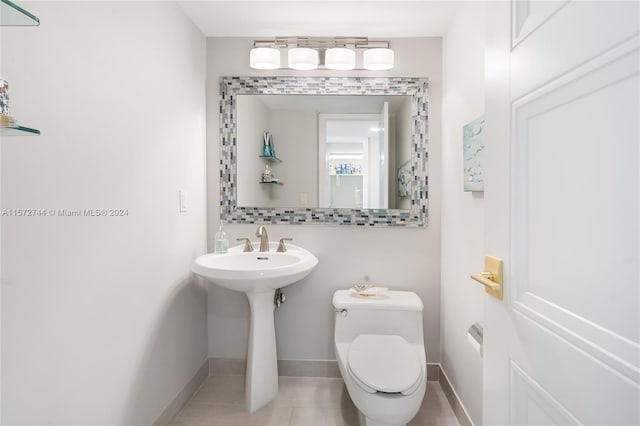 bathroom with toilet and tile floors