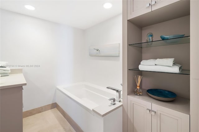 bathroom featuring tile floors, vanity, and a bath