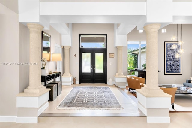 tiled entryway featuring french doors and decorative columns