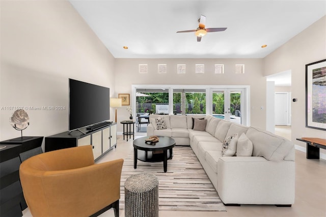 living room with ceiling fan, french doors, and a towering ceiling