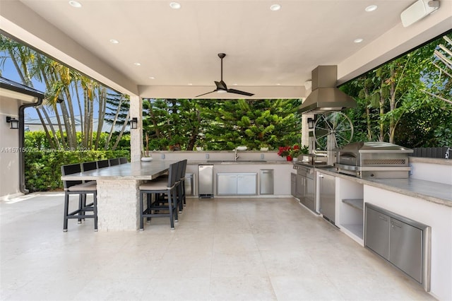 view of terrace with exterior kitchen, a grill, ceiling fan, and a wet bar