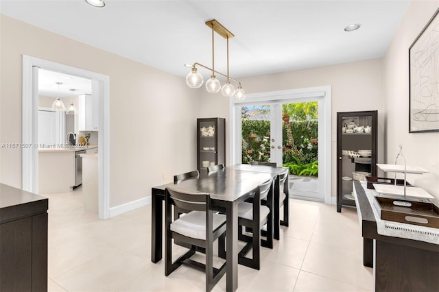 dining area with french doors, sink, and light tile floors