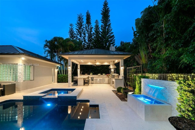 view of pool with exterior kitchen, a patio area, a gazebo, and an in ground hot tub