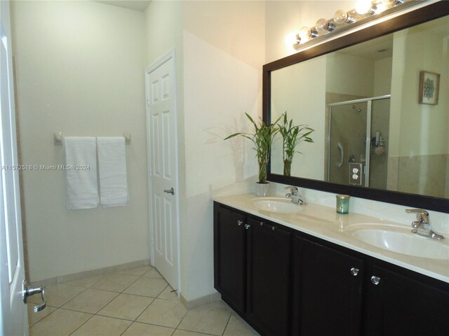 bathroom with walk in shower, double vanity, and tile flooring