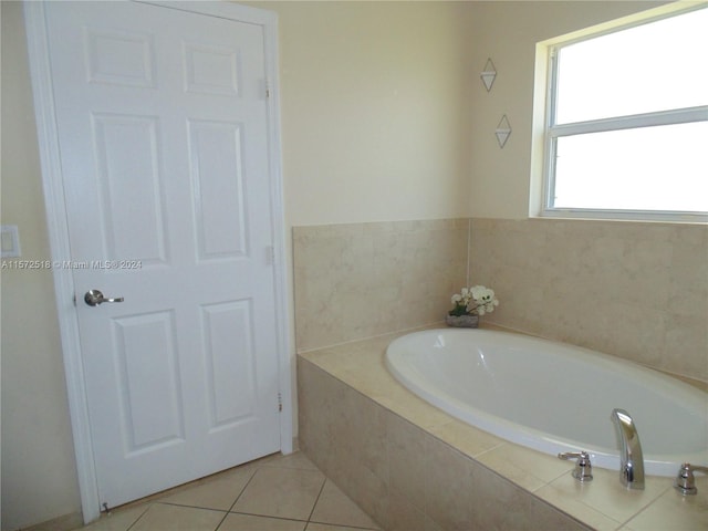 bathroom featuring tiled tub and tile floors