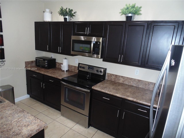 kitchen with stainless steel appliances and light tile floors