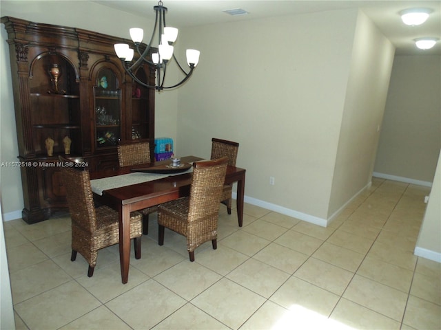 dining space with light tile floors and a chandelier