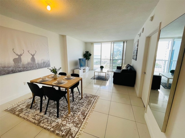 tiled dining room featuring floor to ceiling windows, a textured ceiling, and a wealth of natural light