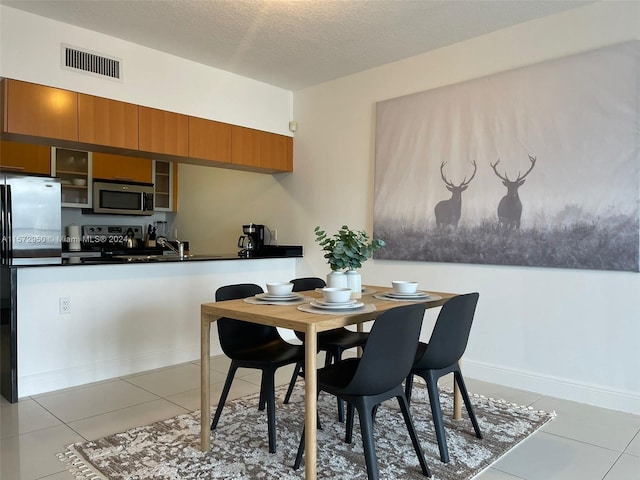 dining room featuring light tile flooring and a textured ceiling