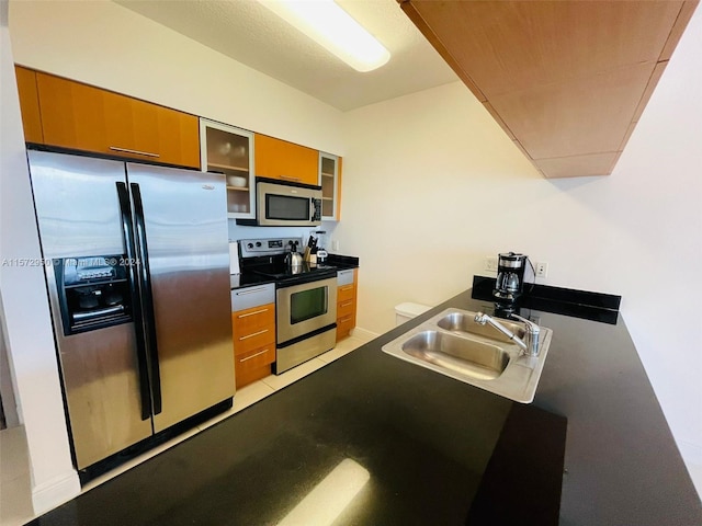 kitchen with sink, light tile flooring, and stainless steel appliances