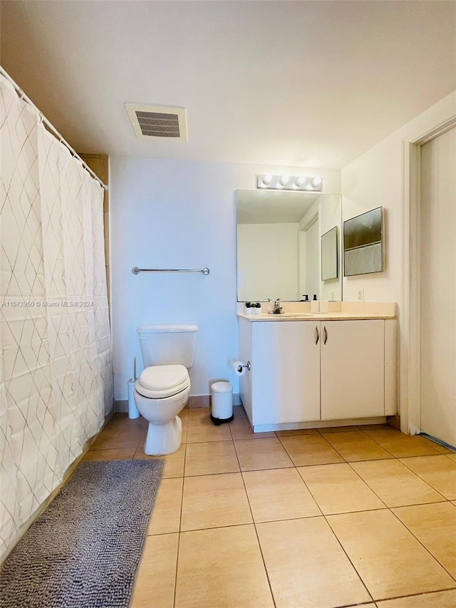 bathroom with vanity, tile floors, and toilet