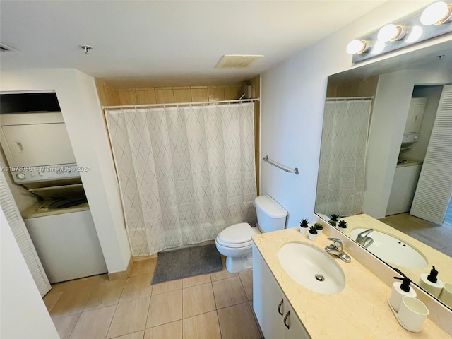 bathroom with vanity with extensive cabinet space, toilet, stacked washer / drying machine, and tile flooring